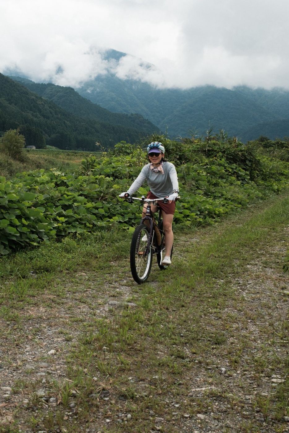 山あいの草の道を自転車で走る